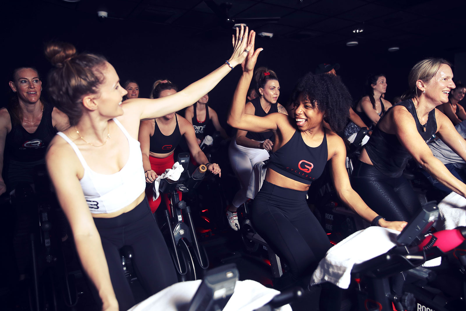 Two people high-fiving at CycleBar